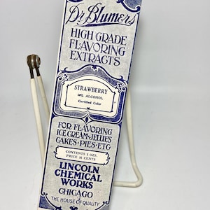 May include: A vintage box of Dr. Blumers High Grade Flavoring Extracts in Strawberry flavor. The box is white with blue lettering and a blue border. It says "50% Alcohol Certified Color" and "Contents 2 ozs. Price 35 cents".