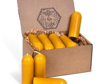 May include: A box of 12 beeswax candles in a cardboard box with the words "the light" and a bee logo. The candles are yellow and have a rounded tip.