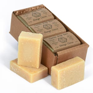 May include: A box of six bars of orange citrus Castile soap. The soap is handmade in the Shenandoah Valley and made with fair trade organic oils. The soap bars are arranged in a box with a brown paper exterior.