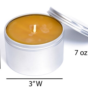 May include: A 7 ounce, silver tin candle with a yellow wax top and a single wick. The candle is 2 inches tall and 3 inches wide.