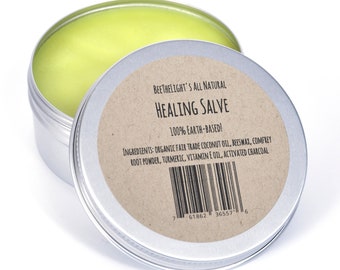 May include: A silver tin with a brown label that reads "BEETHELIGHT'S ALL NATURAL HEALING SALVE 100% EARTH-BASED!" and lists the ingredients: "ORGANIC FAIR TRADE COCONUT OIL, BEESWAX, COMFREY ROOT POWDER, TURMERIC, VITAMIN E OIL, ACTIVATED CHARCOAL". The tin is open and a yellow salve is visible inside.