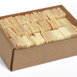 May include: A cardboard box filled with rectangular bars of ivory-colored soap.