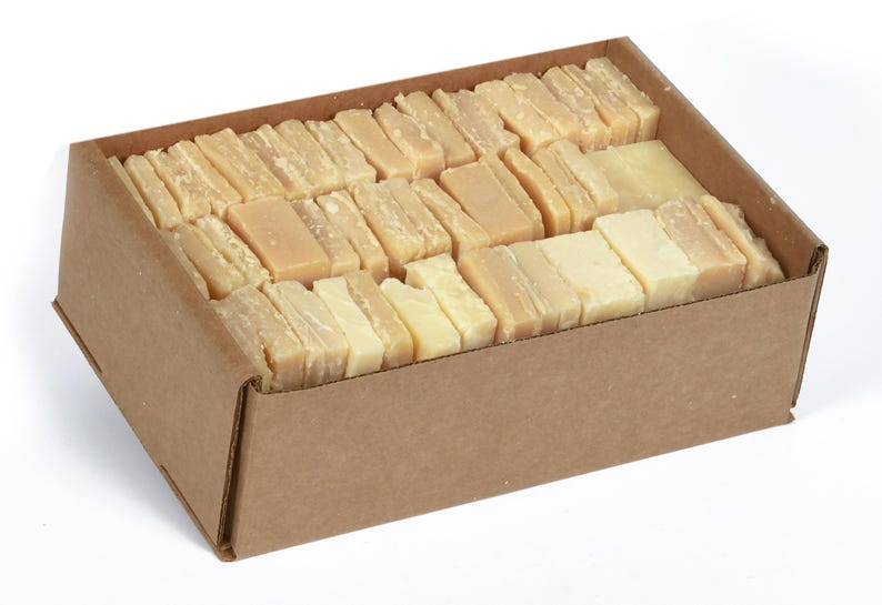 May include: A cardboard box filled with rectangular bars of ivory-colored soap.