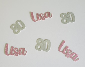 May include: Pink and silver glitter confetti with the name "Lisa" and the number "80" printed on them.