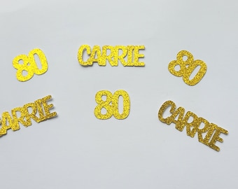 May include: Gold glitter confetti with the number 80 and the name Carrie.