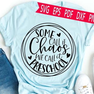 Puede incluir: Camiseta azul claro con el texto negro "Some call it Chaos, we call it Preschool" en un diseño circular. También se ve una pancarta roja con "SVG EPS PDF DXF PNG". La camiseta se combina con vaqueros azules y zapatillas blancas.