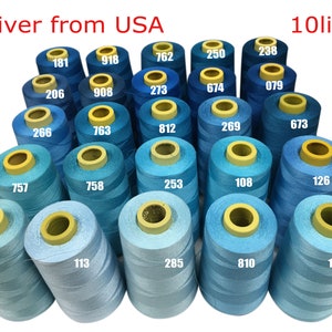 May include: A collection of blue thread spools in various shades, numbered with white digits. The image includes the text "Deliver from USA" and "10lines". The spools are arranged closely together, showcasing a range of blues.