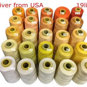 May include: A collection of 19 spools of thread in various shades of yellow, orange, and cream. Each spool is labeled with a number. The text "Deliver from USA" and "19lines" are visible in the image.