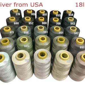 May include: A collection of 18 spools of thread in various shades of green, beige, and grey. The spools are arranged in a triangular pattern and have yellow plastic caps. The text "Deliver from USA" and "18lines" is visible at the top of the image.