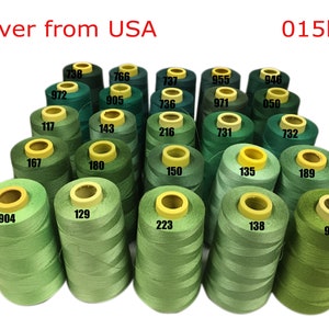 May include: A collection of 15 spools of green thread, each with a different number printed on the side. The spools are arranged in a pyramid shape.