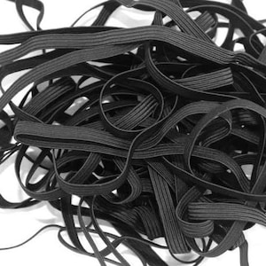 Puede incluir: Primer plano de una gran pila de elástico negro, o tejido elástico. El elástico está enrollado apretado y parece estar en una cantidad a granel.