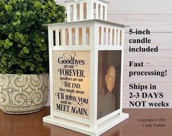 May include: White memorial lantern with a 5-inch candle included. The lantern features a photo and the text "Goodbyes are not FOREVER. I'll miss you until we MEET AGAIN." The lantern has a handle and is on a white base.