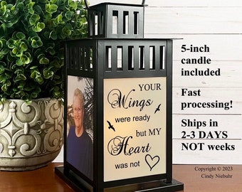 May include: Black metal lantern with a handle, featuring a photo and the text "YOUR Wings were ready but MY Heart was not." Includes a 5-inch candle. Decorative item for memorial or remembrance.
