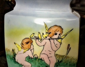 Jarrón antiguo de porcelana alemana Art Déco, firmado por un artista, con querubines tocando la flauta y palomas, fechado en 1928.