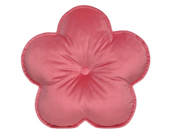 May include: A pink flower-shaped pillow with a button in the center. The pillow is made of a soft, plush fabric.