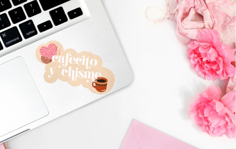 May include: A sticker with a light brown background and white text that reads "cafecito y chisme". The sticker features a pink and brown pastry and a brown coffee mug.