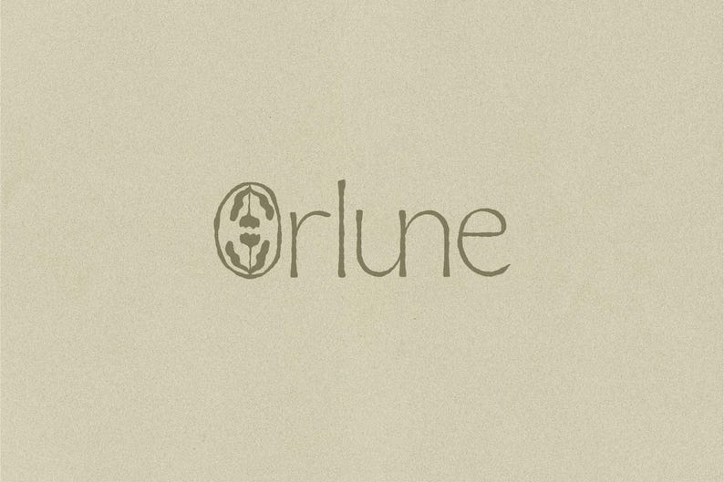K&ouml;nnte beinhalten: Ein Logo-Design mit dem Schriftzug "orlune" in einer d&uuml;nnen, dunkelbraunen, handgezeichneten Schriftart. Der Buchstabe "o" wird durch eine ovale Form ersetzt, die eine symmetrische, stilisierte botanische Illustration mit zwei kleinen Bl&uuml;tenformen enth&auml;lt.
