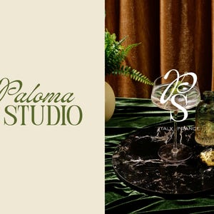 May include: The image features a black marble tray with a clear glass, two decorative glass bottles, and a gold-colored object. The background includes a green velvet surface and a brown curtain. The text "Paloma STUDIO" is visible.