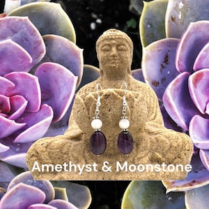 May include: Amethyst and moonstone earrings with silver hooks. The earrings feature a purple amethyst gemstone and a white moonstone bead.