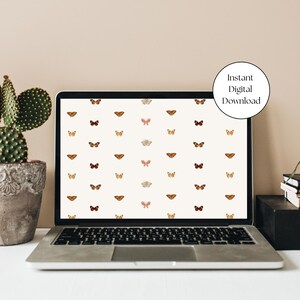 May include: A laptop computer displaying a digital wallpaper with a pattern of brown, orange, and white butterflies on a white background. The text "Instant Digital Download" is displayed in a circle on the screen.
