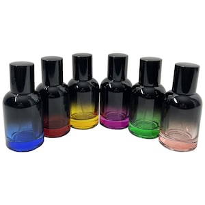May include: Six glass perfume bottles with black caps and gradient color schemes. The bottles transition from dark black at the top to blue, red, yellow, purple, green, and pink at the base. The bottles are arranged in a row.