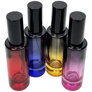 May include: Four glass perfume bottles with black caps. The bottles are in shades of red, blue, yellow, and purple. The bottles are cylindrical and appear to be empty. The caps are tall and cylindrical.