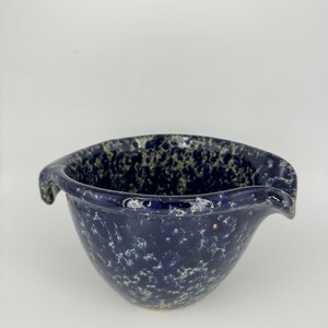 May include: A blue ceramic mixing bowl with a speckled glaze and two pouring spouts.