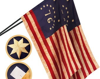 May include: Two American flags with 13 red and white stripes and a blue canton with 13 white stars. The canton of each flag has the number "1776" in gold lettering.