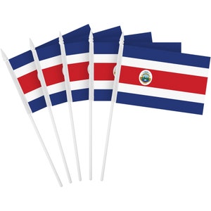 May include: A collection of Costa Rican flags on white plastic sticks. Each flag features a blue and white striped design with a red stripe in the center. One flag displays the Costa Rican coat of arms.