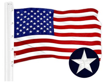 May include: American flag with red and white stripes and a blue canton filled with white stars. A navy blue patch with a white star is in the lower right corner. The flag is attached to a white pole.