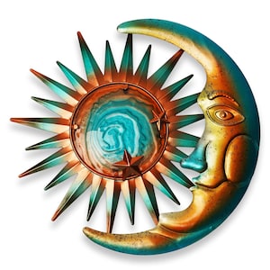May include: A celestial-themed metal wall art piece featuring a sun and moon design. The sun has teal and copper-colored rays surrounding a central circular design with blue and white swirls. The crescent moon has a face with an orange and teal color scheme.