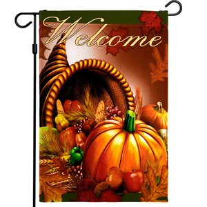 May include: A fall-themed garden flag with a cornucopia overflowing with pumpkins, apples, corn, and other autumn harvest items. The flag has a brown background with the word "Welcome" in a decorative font.