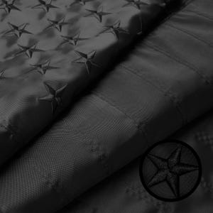 May include: Black American flag with embroidered stars. The flag is folded in half, showing the stars on one side and the stripes on the other.