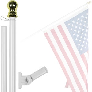 May include: White telescoping flagpole with a gold finial and a white wall mount bracket. The flagpole is extended to its full height and is holding a US flag.