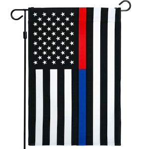 May include: A garden flag with a thin red stripe and a thin blue stripe on a black and white American flag background. The flag is attached to a black metal pole.