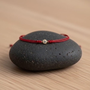 10K solid gold with 0.125 ctw diamond bracelet on nylon cord.