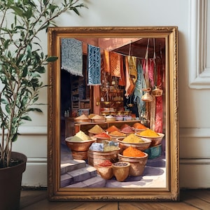 May include: A framed watercolor painting depicts a spice market with various colorful spices in wooden bowls. Hanging textiles in blue, orange, and red add to the scene. The painting is in a gold frame, set on a wooden floor.