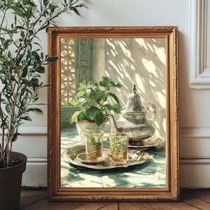 Pode incluir: Pintura emoldurada de natureza morta com uma chaleira de prata, dois copos e uma bandeja. Os copos e a chaleira estão sobre uma superfície semelhante a mármore. Uma planta em vaso e uma janela são visíveis. A moldura é dourada.