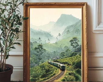 May include: A framed landscape painting depicting a train traveling along tracks through a lush green tea plantation. In the background, misty mountains rise under a pale sky. The artwork is encased in an ornate, metallic gold frame.