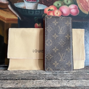 Cartera para pasaporte Louis Vuitton Monogram Couverture Long Passport. Esta cartera plegable luce el icónico monograma marrón.