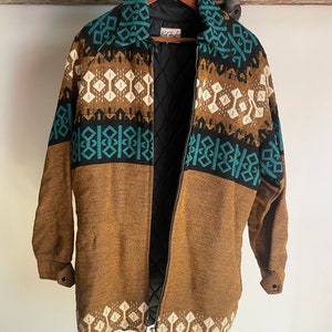May include: A brown, black, and teal patterned jacket with a zipper closure. The jacket has a quilted lining and a label that reads "Old Stock".