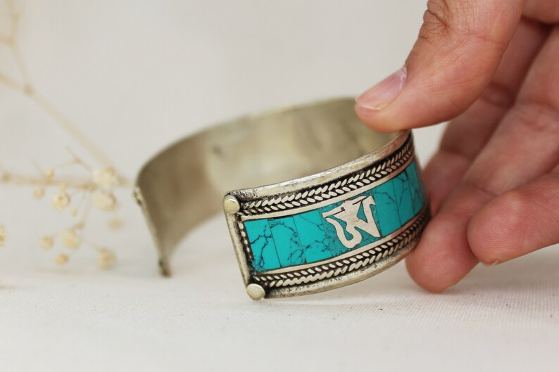 Handmade by artisans from Nepal. SUNITA TURQUESA PULSERA \u2013 Metal bracelet and stones tinted in turquoise with mantra