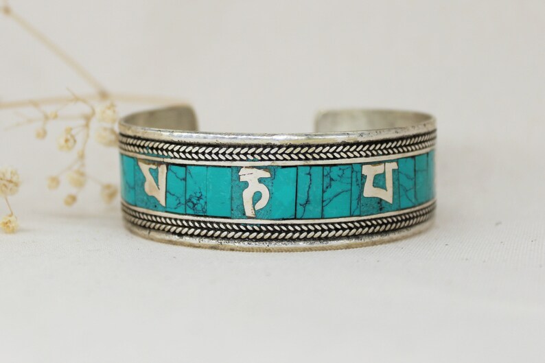Handmade by artisans from Nepal. SUNITA TURQUESA PULSERA \u2013 Metal bracelet and stones tinted in turquoise with mantra