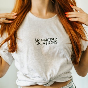 ASH GRAY Embroidered Liz Martinez Creations Short-Sleeve Unisex T-Shirt MERCH