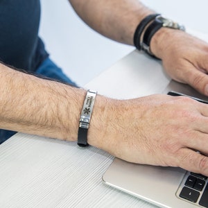 May include: A silver medical alert bracelet with the text "Type 2 Diabetes" and a star of life symbol. The bracelet is worn on a person's wrist.