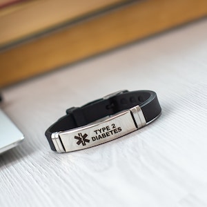 May include: Black silicone bracelet with a silver metal plate engraved with a medical symbol and the text "TYPE 2 DIABETES".