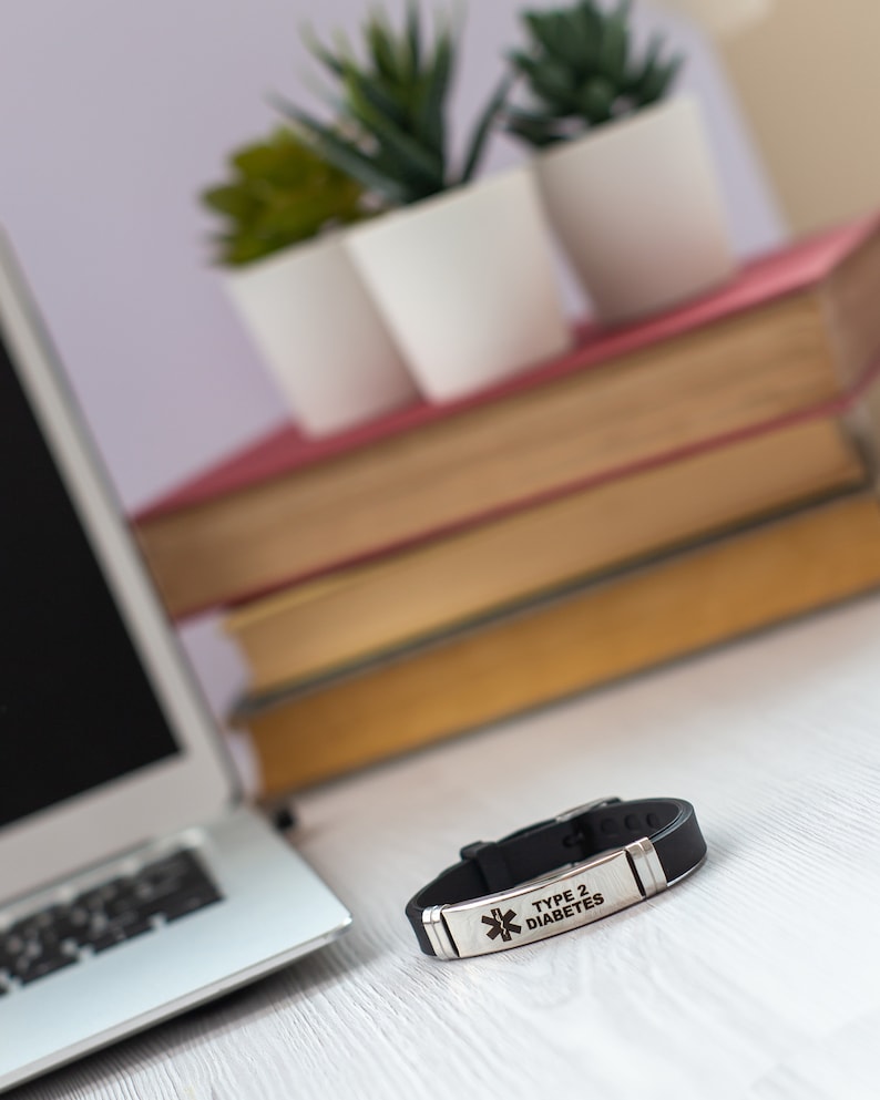 May include: Black silicone medical alert bracelet with a silver metal plate engraved with "TYPE 2 DIABETES".