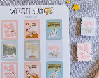 Peut inclure: Une feuille d'autocollants avec une variété d'illustrations. Les autocollants sont dans une palette de couleurs pastel et présentent des images de fleurs, d'arbres et d'une grenouille. La feuille est étiquetée "Woodtuft Studio" et "@woodtuft".