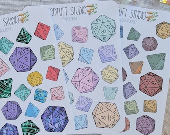 May include: Three sheets of stickers featuring colorful, illustrated dice with different numbers. The stickers are on a white background and have the text "WOODTUFT STUDIO @WOODTUFT" on each sheet.