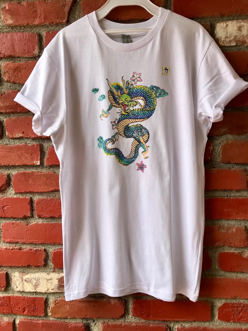 May include: White t-shirt with a colorful dragon graphic and the Japanese character "九" printed on the front.